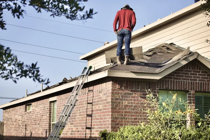Professional roofer working on a residential roof in Manhasset Hills